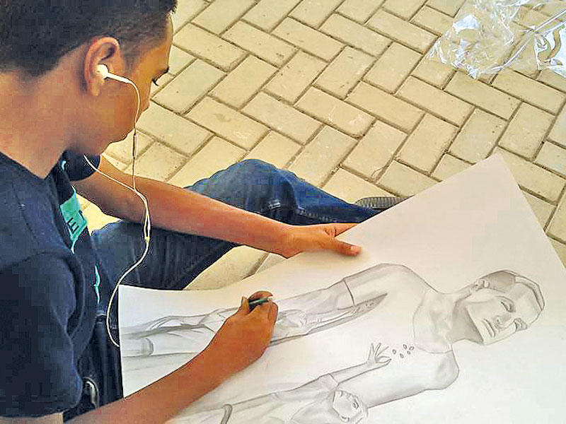 شاب يرسم صورة للزعيم جمال عبد الناصرn