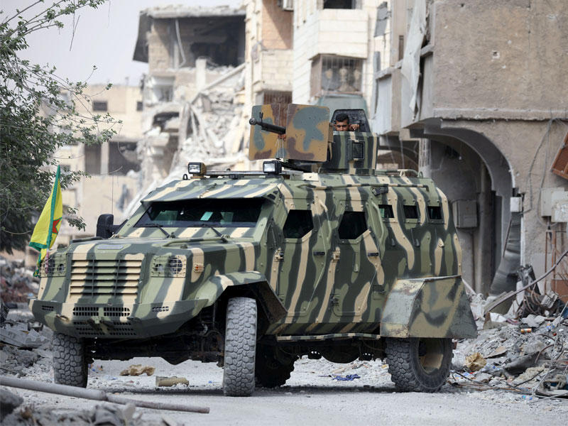 مقاتل من القوات السورية يجلس في دبابة عسكرية في الرقة