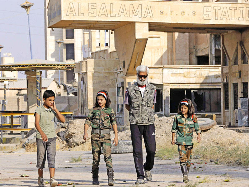 سوري في جولة مع أولاده بمدينة دير الزور أمس (أ ف ب)