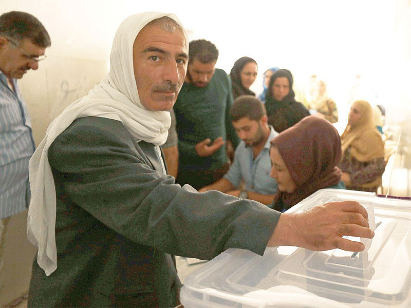 كردي سوري يدلي بصوته في الانتخابات البلدية «الكومونات» بالقامشلي أمس (رويترز)n