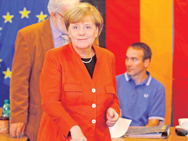 ميركل أثناء إدلائها بصوتها في برلين أمس (رويترز)