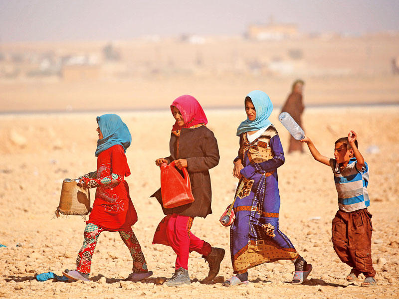 فتيات يبحثن عن مصدر ماء خارج مخيم عين عيسى أمس الأول (أ ف ب)