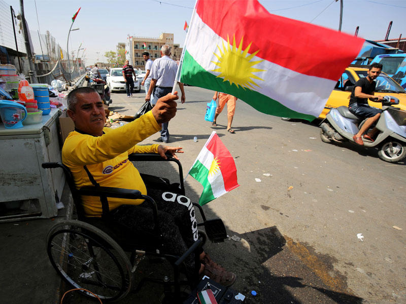 رجل يحمل علم كردستان في وسط كركوك