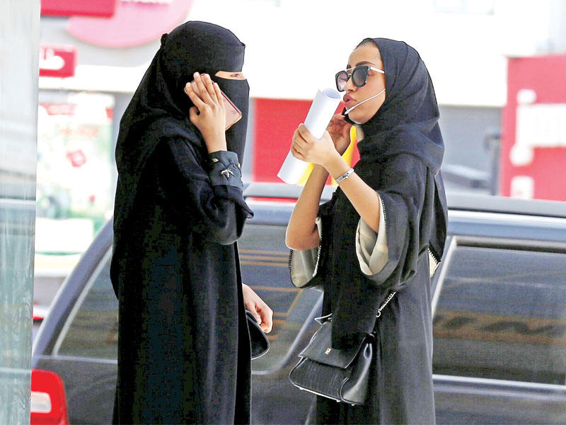 سعوديتان تسيران في الرياض (رويترز)