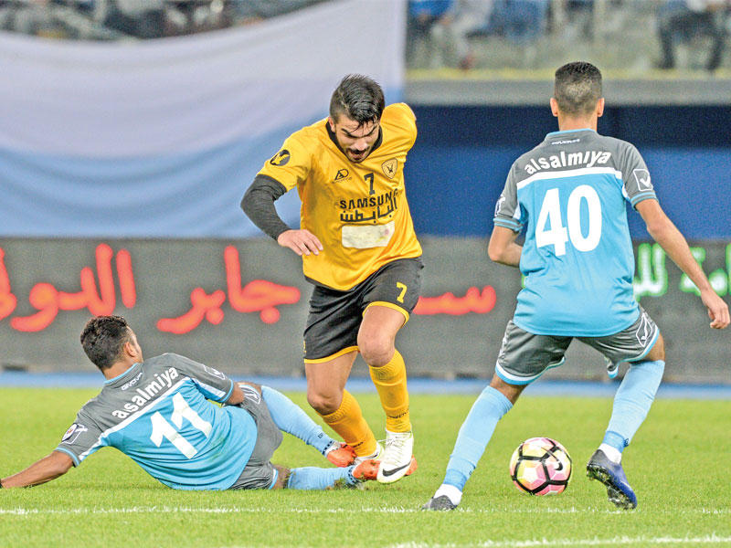 أحمد الرياحي لاعب القادسية يحاول المرور من بين مدافعي السالمية في لقاء سابق