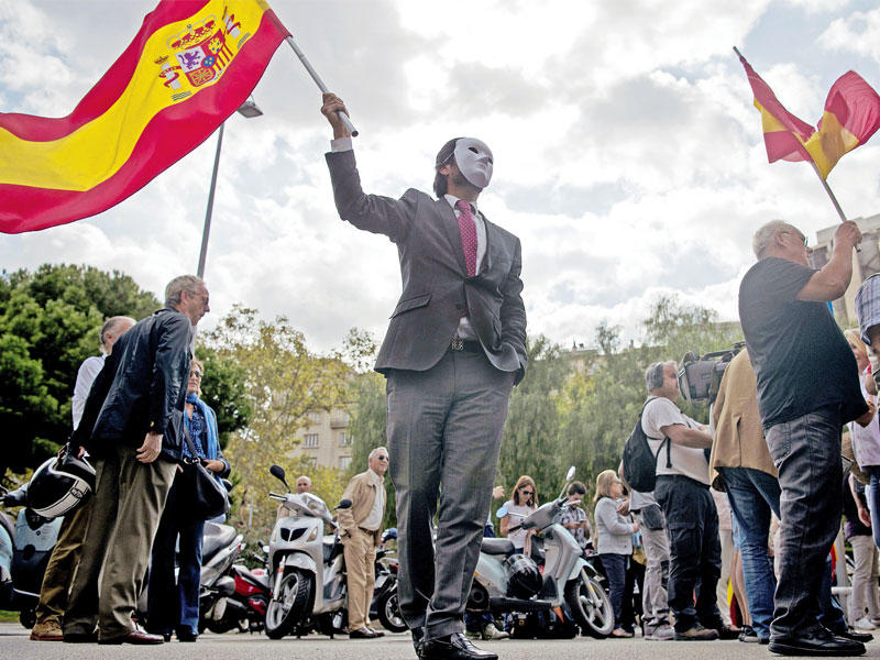 كاتالوني مقنع مؤيد للاستقلال خلال تظاهرة في برشلونة أمس (أ ف ب)