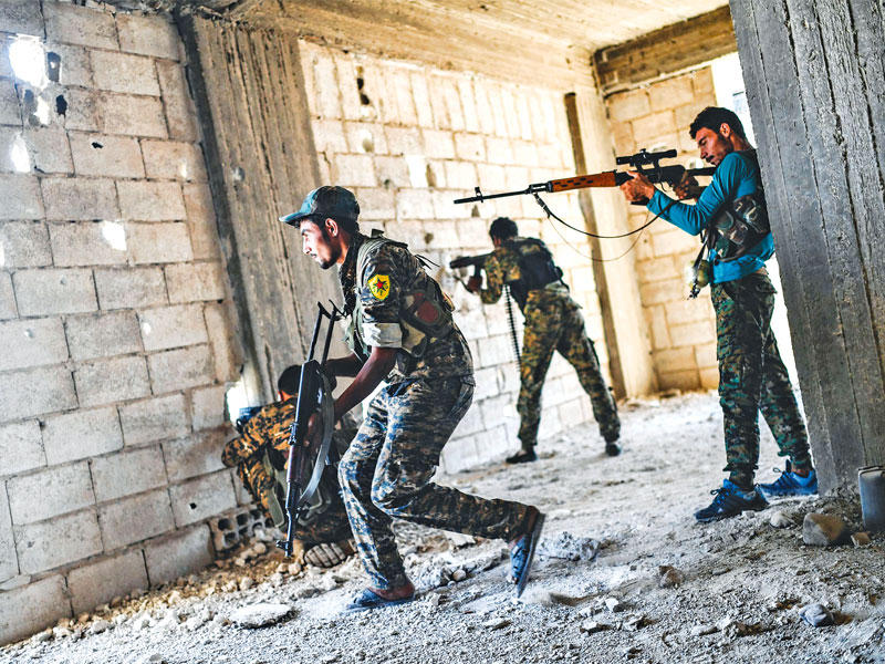 عناصر من قوات سورية الديمقراطية في مواجهة مع «داعش» بمحيط مستشفى الرقة المركزي أمس (أ ف ب)