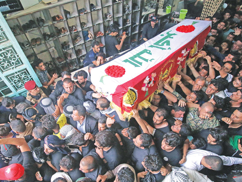 عراقيون يشيعون في البصرة أمس القناص الشهير في «الحشد الشعبي» أبو تحسين الصالحي الذي تردد أنه قتل 350 من «داعش»  (أ ف ب) 