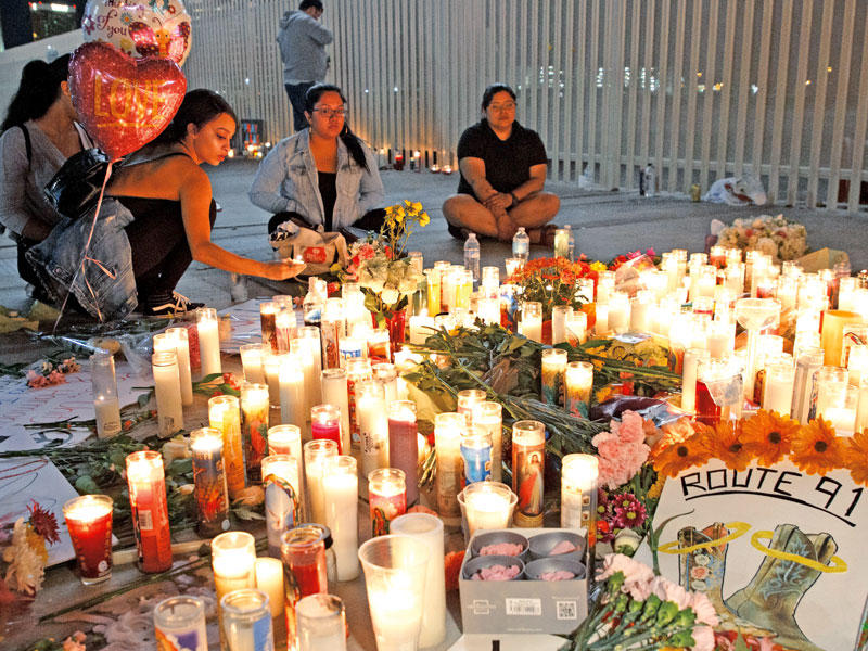 أميركيون يضيئون شموعاً في موقع اعتداء لاس فيغاس أمس الأول (أي بي أيه)