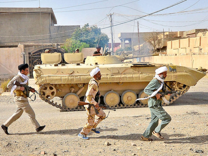 رجال دين شيعة يقاتلون مع «الحشد» في الحويجة أمس (رويترز)