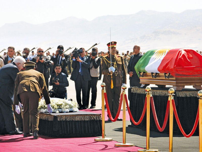 الرئيس العراقي فؤاد معصوم يضع الزهور على نعش الرئيس السابق جلال الطالباني خلال مراسم جنائزية في مطار السليمانية (أ ف ب)