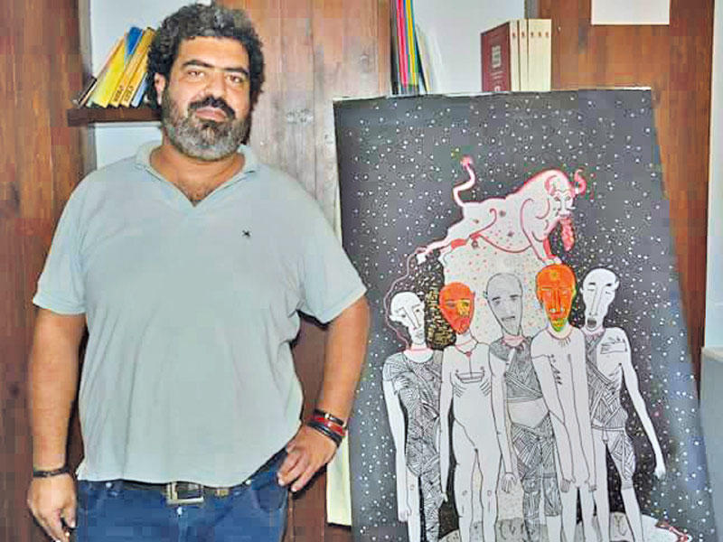 محمد عبد الهادي إلى جانب إحدى لوحاتهn