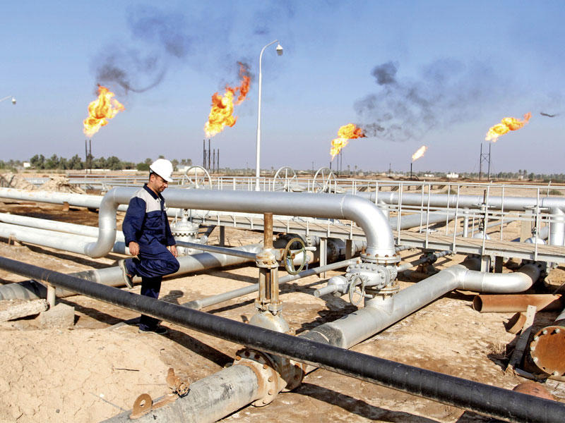 أحد عمال النفط في محطة لأنابيب النفط في شمال البصرة أمس (رويترز)