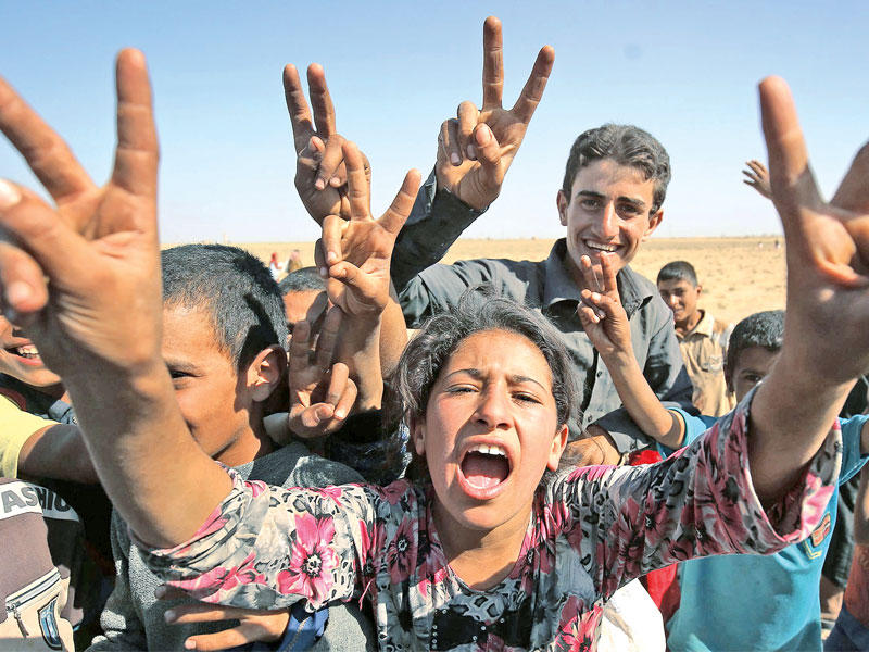 أطفال عراقيون نازحون يرفعون شارة النصر بتحرير قضائهم الحويجة في 7 أكتوبر الجاري    (أ ف ب)