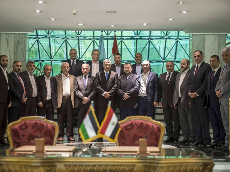 وزير المخابرات المصرية متوسطاً الأحمد والعاروري عقب التوقيع على اتفاق المصالحة في القاهرة أمس	(أ ف ب) 