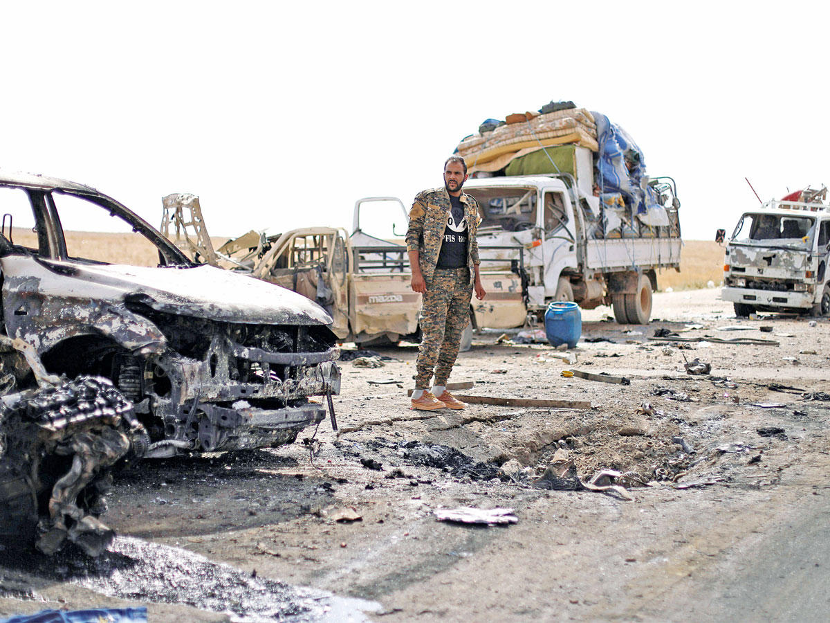 مقاتل كردي في موقع هجوم «داعش» على الفارين إلى محافظة الحسكة (رويترز)