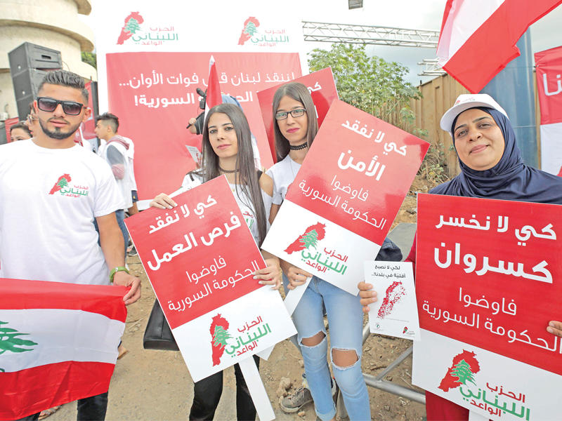 تظاهر عشرات الأشخاص من حزب مغمور في بلدة زوق مصبح، شمال بيروت، أمس، للمطالبة بمغادرة اللاجئين السوريين الذين يتجاوز عددهم المليون، لبنان، داعين إلى التفاوض مع الحكومة السورية، الأمر الذي ترفضه قوى سياسية مشاركة في الحكومة. وفي الصورة جانب من التظاهرات.