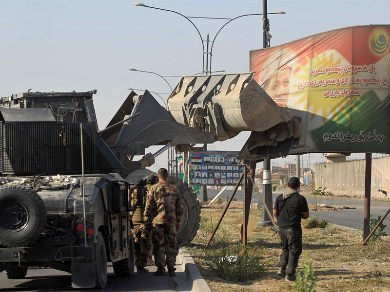 جنود عراقيون يزيلون صورة للبارزاني في كركوك أمس (أ ف ب)