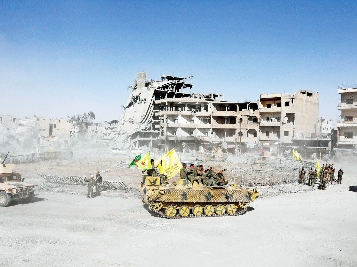 مقاتلو «قسد» يحتفلون بالنصر في الرقة أمس (رويترز)