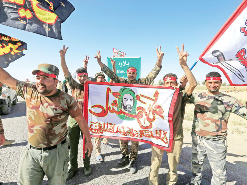 مقاتلون في الحشد الشعبي يرفعون شعارات دينية احتفالاً بالسيطرة على كركوك أمس (رويترز)