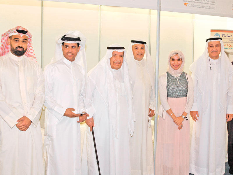 الغانم مع مجموعة من الشباب المشاركين في المعرض