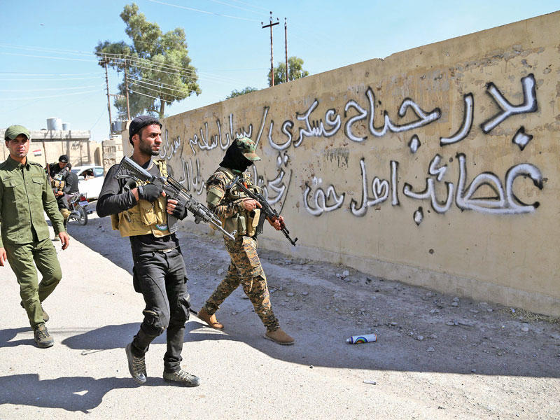 مقاتلون من ميليشيات «منظمة بدر» الشيعية يجوبون كركوك قبل انسحابهم المفترض منها (إي بي أيه)