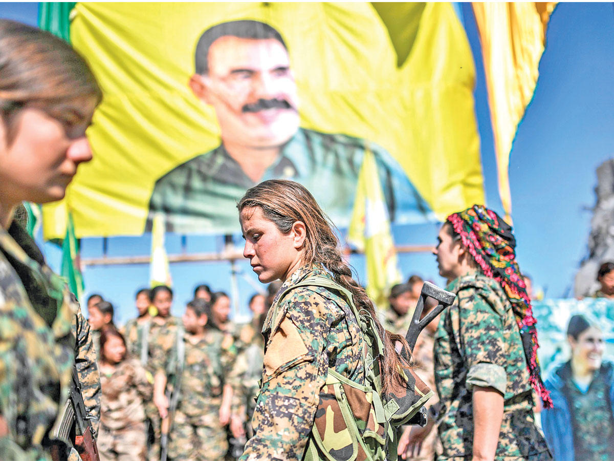 مقاتلات كرديات يحتفلن تحت راية أوجلان في ساحة النعيم الشهيرة وسط الرقة (أ ف ب)