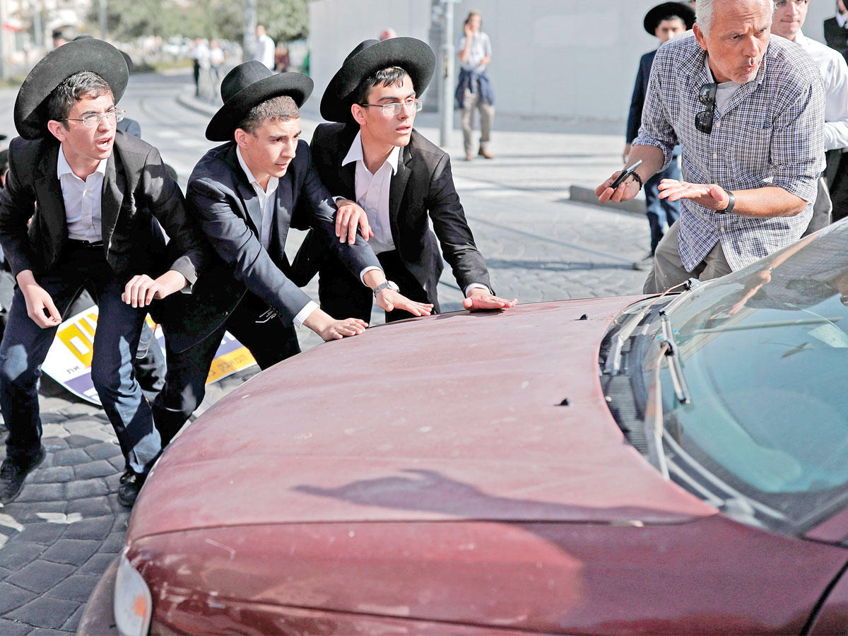 متشددون يهود يتظاهرون في القدس رفضاً لقانون يجبرهم على الخدمة الإلزامية في الجيش بعد أن كانوا معفيين من ذلك (أ ف ب)