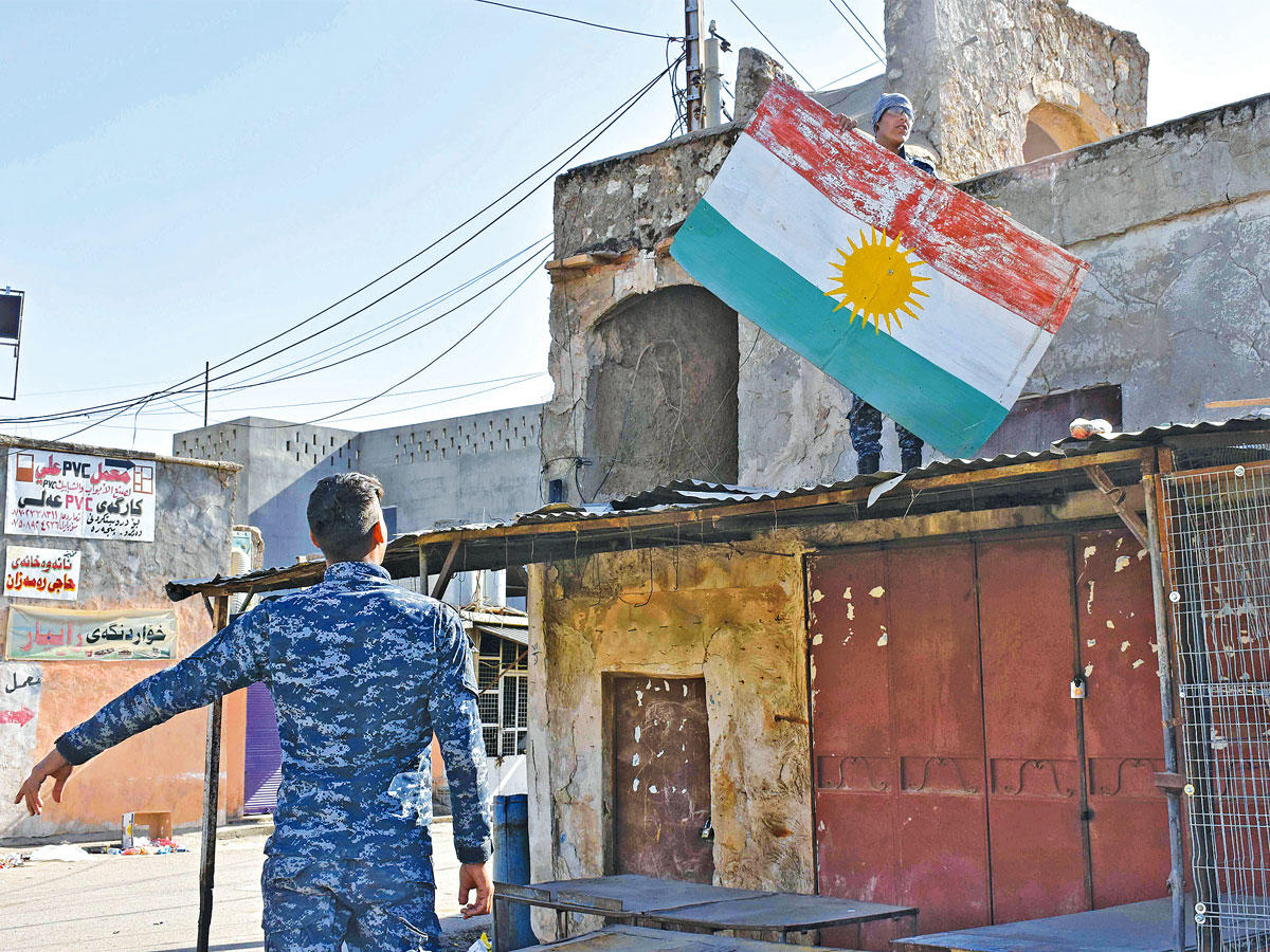 مقاتل عراقي ينزع العلم الكردي من مبنى في كركوك (أ ف ب)