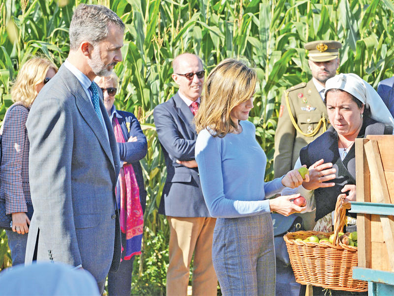 ملك إسبانيا فيليب السادس والملكة ليتيسيا يتذوقان عصير التفاح في مدينة بوريون شمال إسبانيا التي يتحدث ساكنوها بالنمساوية (رويترز)  