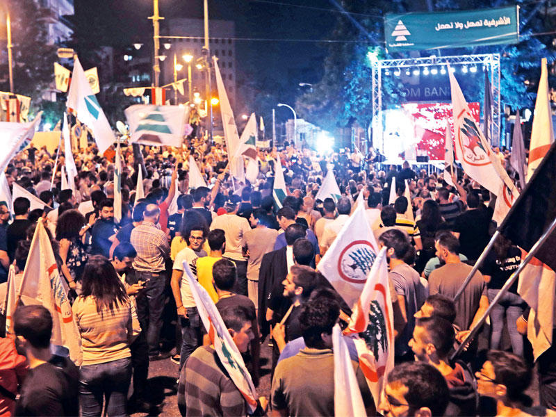مؤيدون للقوات والكتائب في ساحة ساسين بالأشرفية مساء الجمعة بعد صدور قرار المحكمة بحق قتلة بشير الجميل  (أ ف ب)