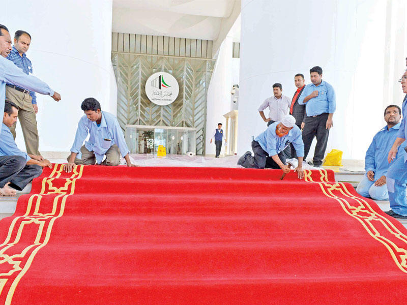 عمال يضعون الفرش الأحمر استعداداً للجلسة الافتتاحية لدور الانعقاد الجديد