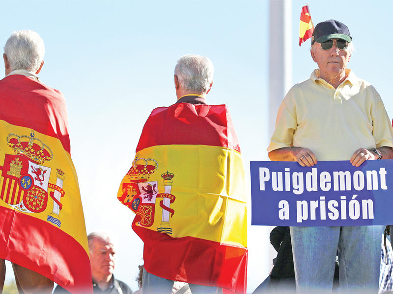 متظاهر يرفع لافتة تدعو إلى سجن بوتشيمون خلال تظاهرة وحدوية  في مدريد  (رويترز)