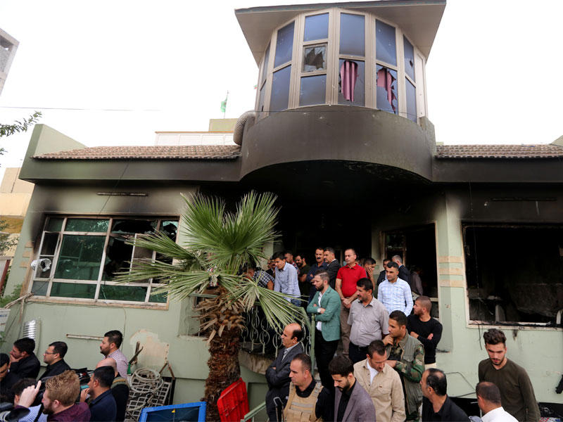 أعضاء حزب الاتحاد الكردستاني يتجمعون أمام مقرهم في زاخو بعد حرقه أمس(رويترز)