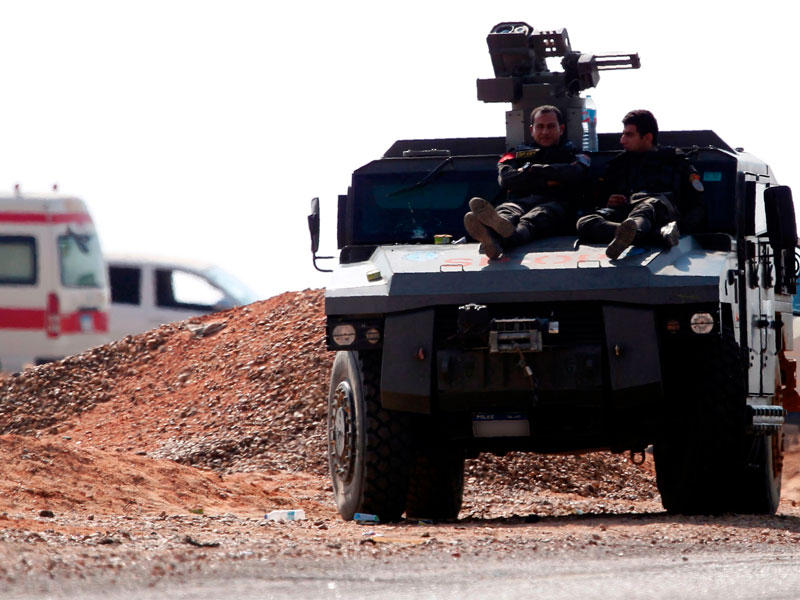 قوات الأمن المصرية يستقرون على رأس عربة مدرعة متوقفة على الطريق الصحراوي باتجاه واحة البحارية