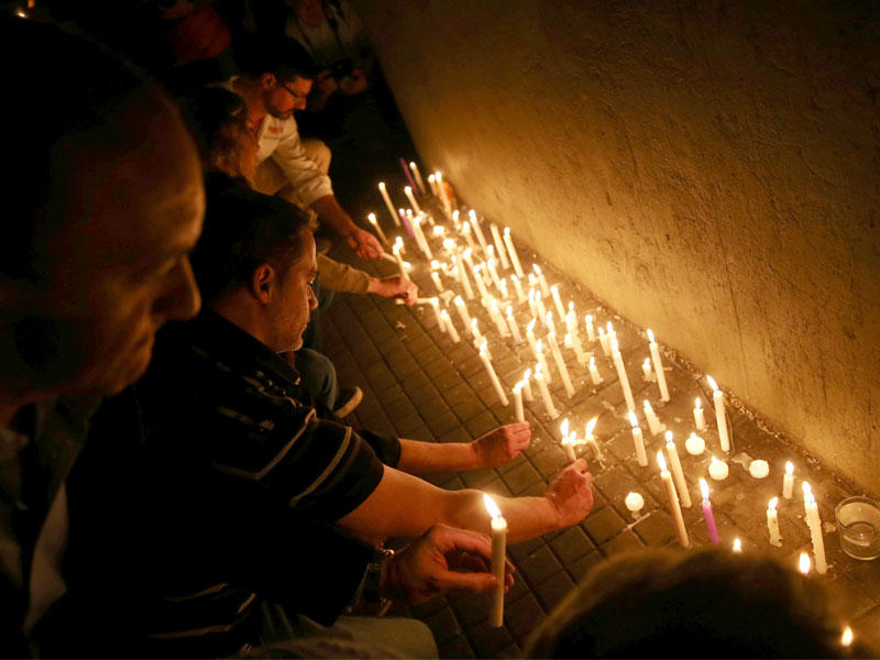 ارجنتينيون يضيئون شموعا مساء أمس الأول في معهد البوليتكنيك في روازريو الذي ارتاده 5 من مواطنيهم قتلوا في عملية الدهس بنيويورك  (رويترز)