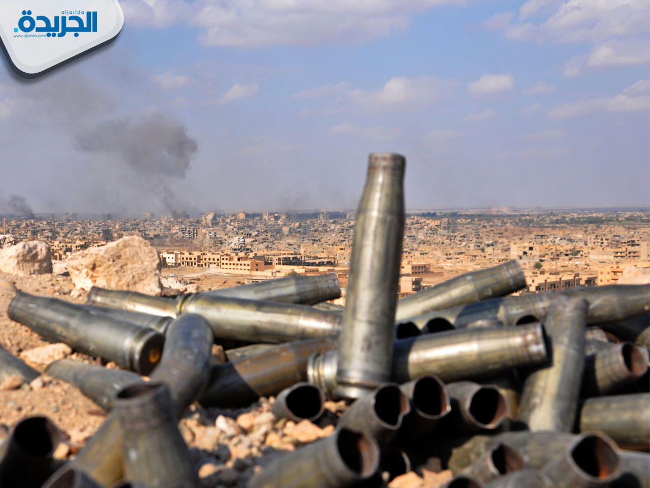 فوارغ طلقات على مشارف دير الزور التي يتصاعد منها الدخان بعد عمليات قوات النظام أمس (أ ف ب)