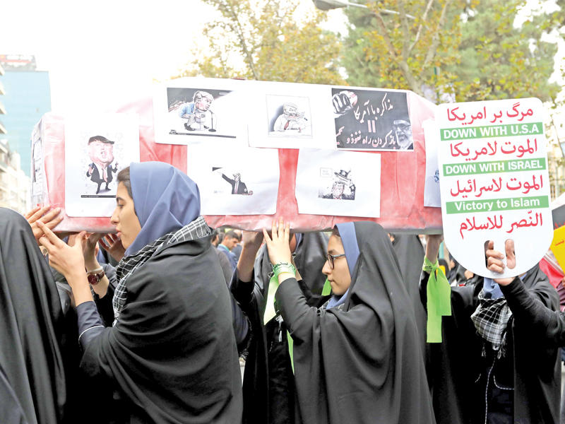 إيرانيات يحملن تابوتاً وهمياً للرئيس الأميركي أمس خلال مراسم الذكرى السنوية لاقتحام سفارة واشنطن السابقة في طهران عام 1979 (أ ف ب)