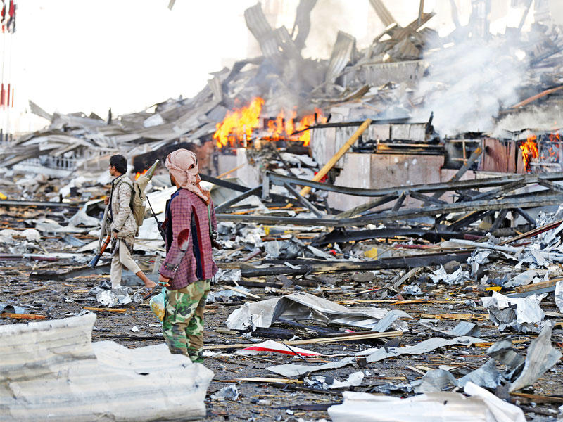 حوثيون في موقع عسكري تعرض لغارة من التحالف في صنعاء أمس الأول  (رويترز)