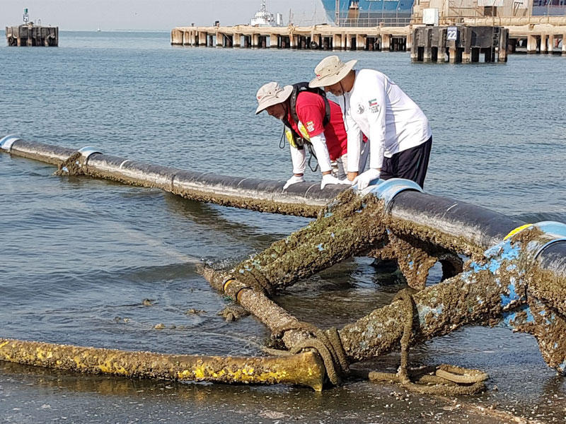 أعضاء فريق الغوص الكويتي التابع للمبرة التطوعية البيئية أثناء انتشال أنابيب لمزارع سمكية جانحة مقابل ساحل مجلس الأمة