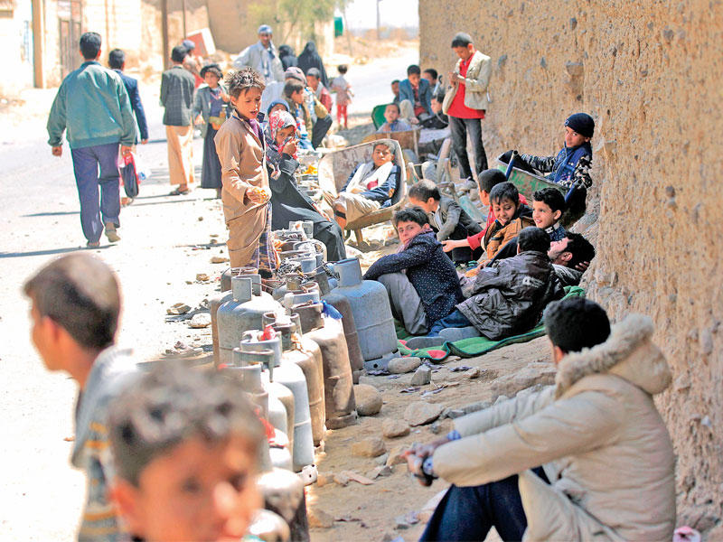 يمنيون ينتظرون دورهم لتعبئة جرار الغاز في صنعاء (أ ف ب)