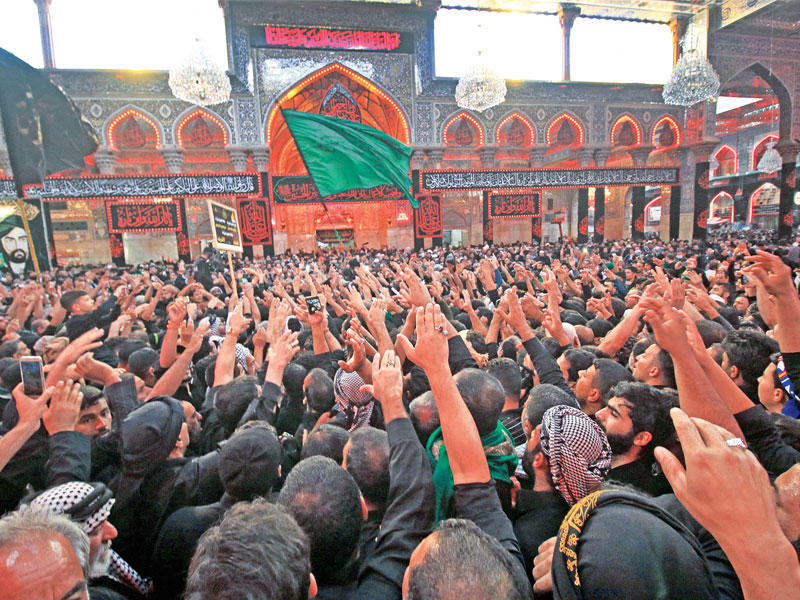 حشود من الزوار تلقي التحية على مقام الإمام الحسين في كربلاء أمس (أ ف ب)n