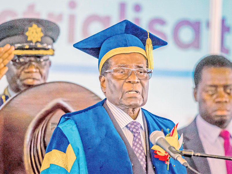 موغابي خلال حفل تخريج في جامعة هراري اليوم ويبدو أحد القادة العسكريين  وراءه (أ ف ب )