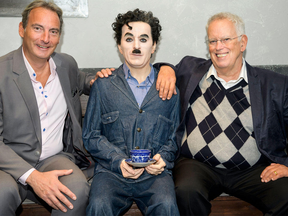 ابن الراحل تشارلي شابلن، يطرح مع مدير المتحف وجان بيير بيجون بجانب شخصية الشمع من والده خلال مؤتمر صحفي