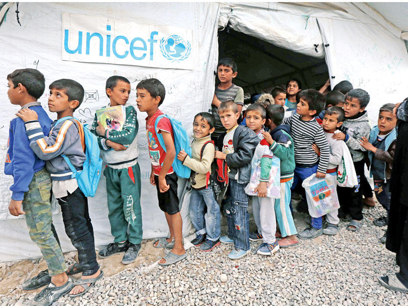 أطفال عراقيون يخرجون من مدرستهم وهي عبارة عن خيمة في مخيم حسن شام للنازحين من الموصل في إقليم كردستان أمس الأول tt   (أ ف ب)