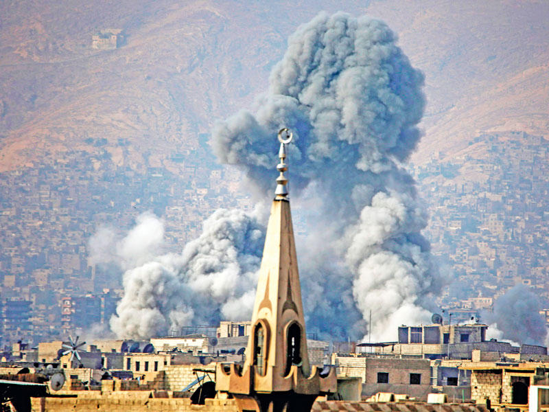 الدخان يتصاعد من موقع تعرض لغارة جوية في عربين قرب دمشق أمسt(أ ف ب)