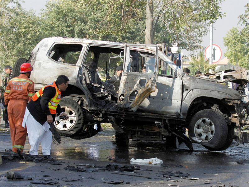 الانقاذ يقومون بتفتيش سيارة تضررت من انتحاري ادى الى مقتل مسؤول كبير في الشرطة الباكستانية