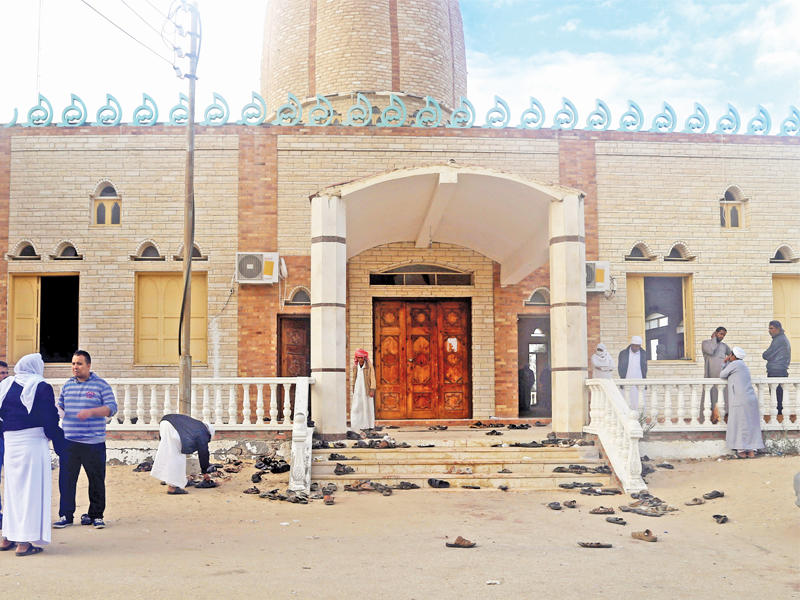 مصريون خارج مسجد الروضة أمس الذي شهد المجزرة المروعة أمس الأول  (رويترز)