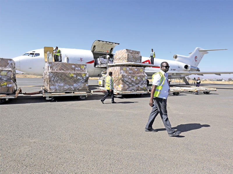 عمال يفرغون طائرة مساعدات بمطار صنعاء أمس (أيه بي أيه) 