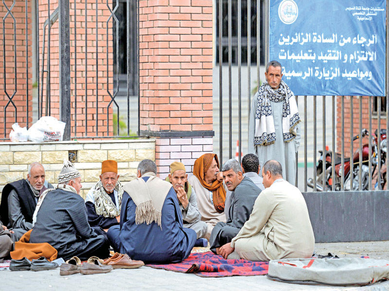 أقارب ضحايا ينتظرون تسلم جثث ذويهم خارج مستشفى السويس الجامعي في الإسماعيلية أمس t(أ ف ب)